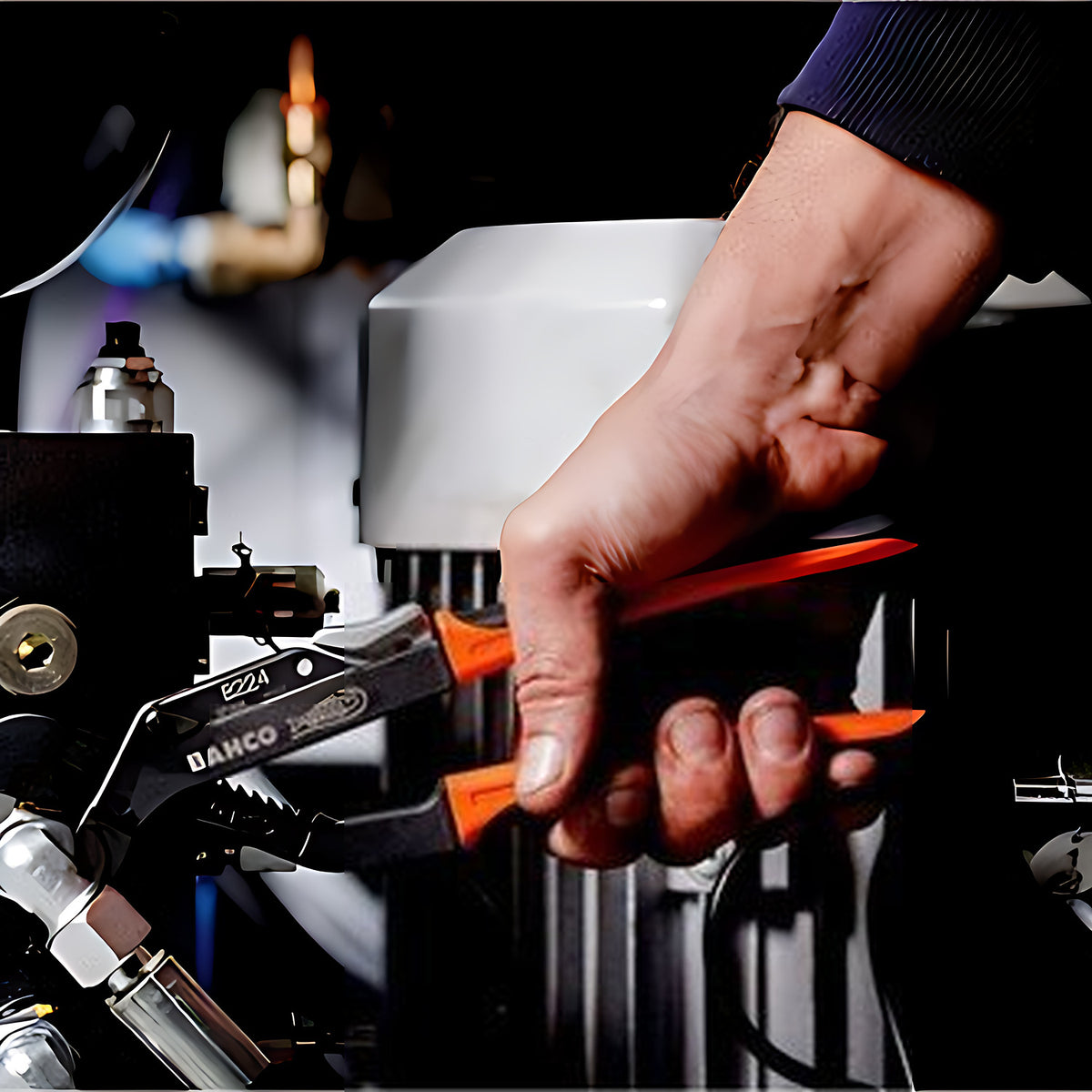 Bahco ERGO slip joint pliers in use gripping a hydraulic fitting on machinery
