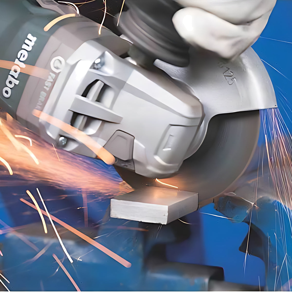 Pferd Duo Steelox wheel on a grey angle grinder, cutting a flat steel bar held in a blue vice, orange sparks