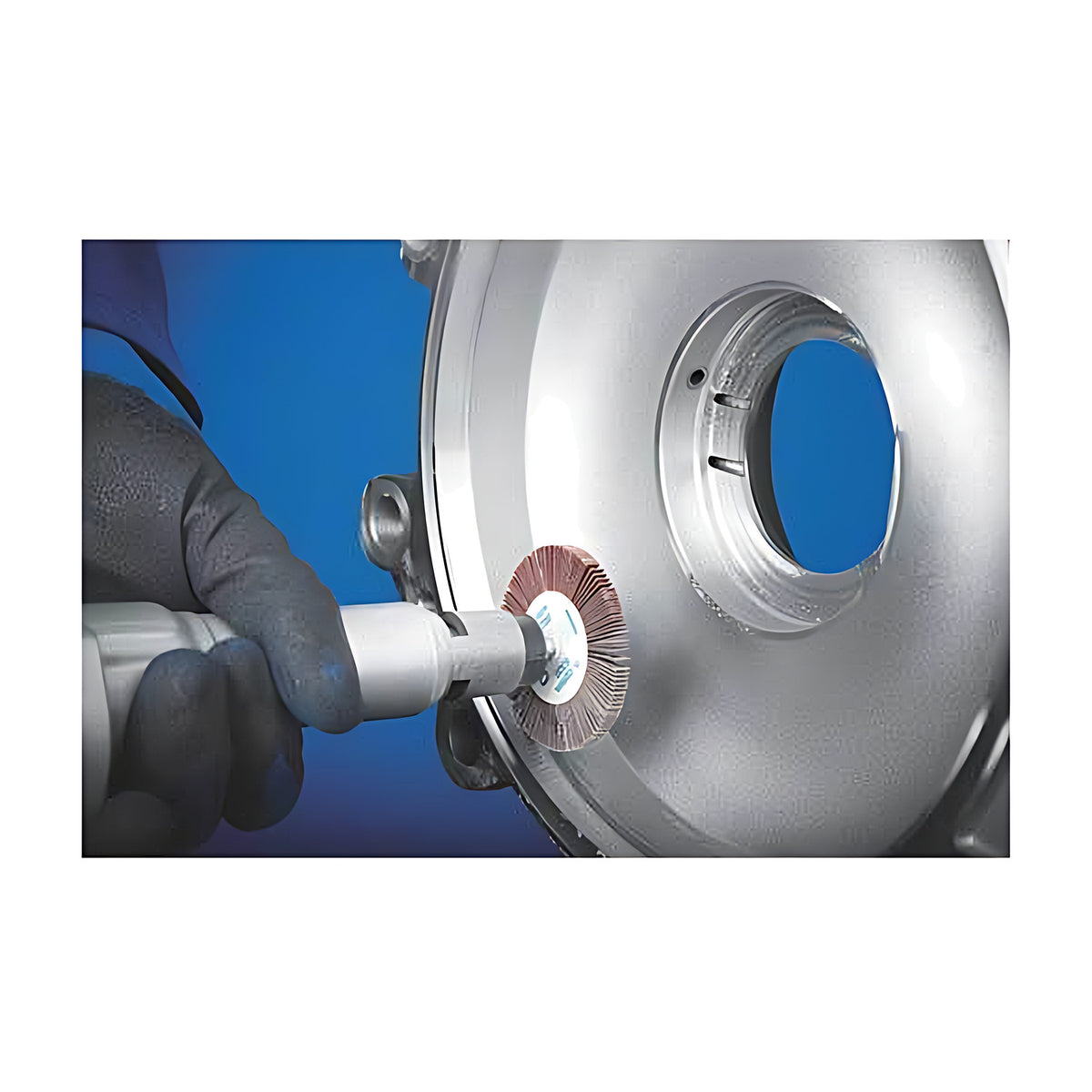 Pferd fan grinder 80 x 40 mm held by a gloved hand against a round silver casting with a central hole, blue background