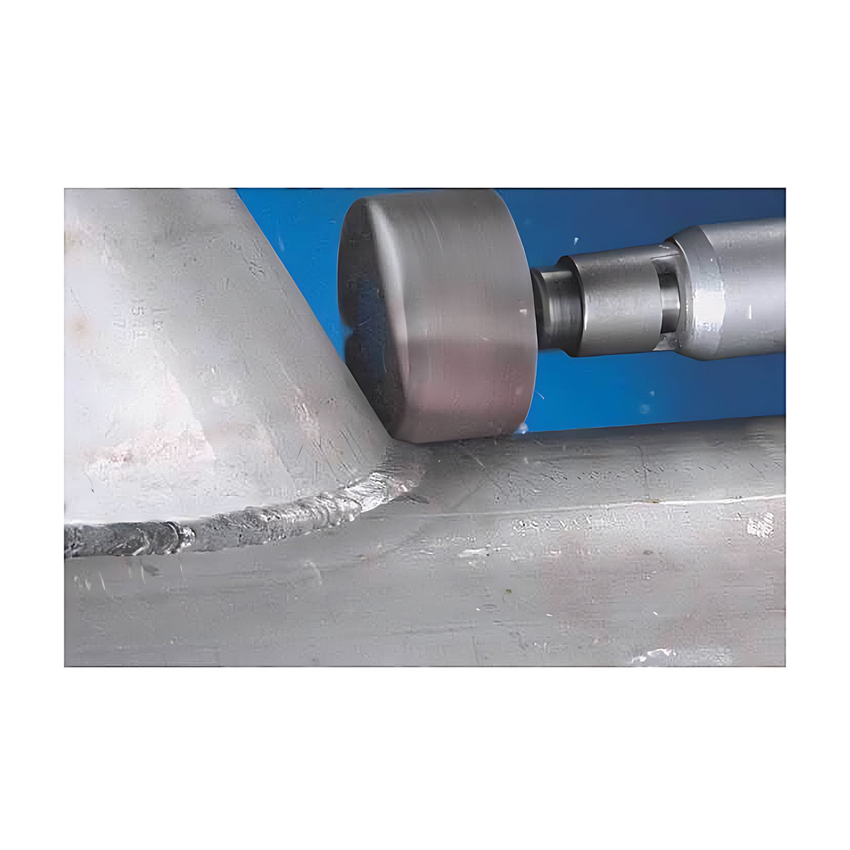 Pferd Z-COOL zirconia alumina fan grinder on a die grinder working a weld bead on a grey metal surface, close view