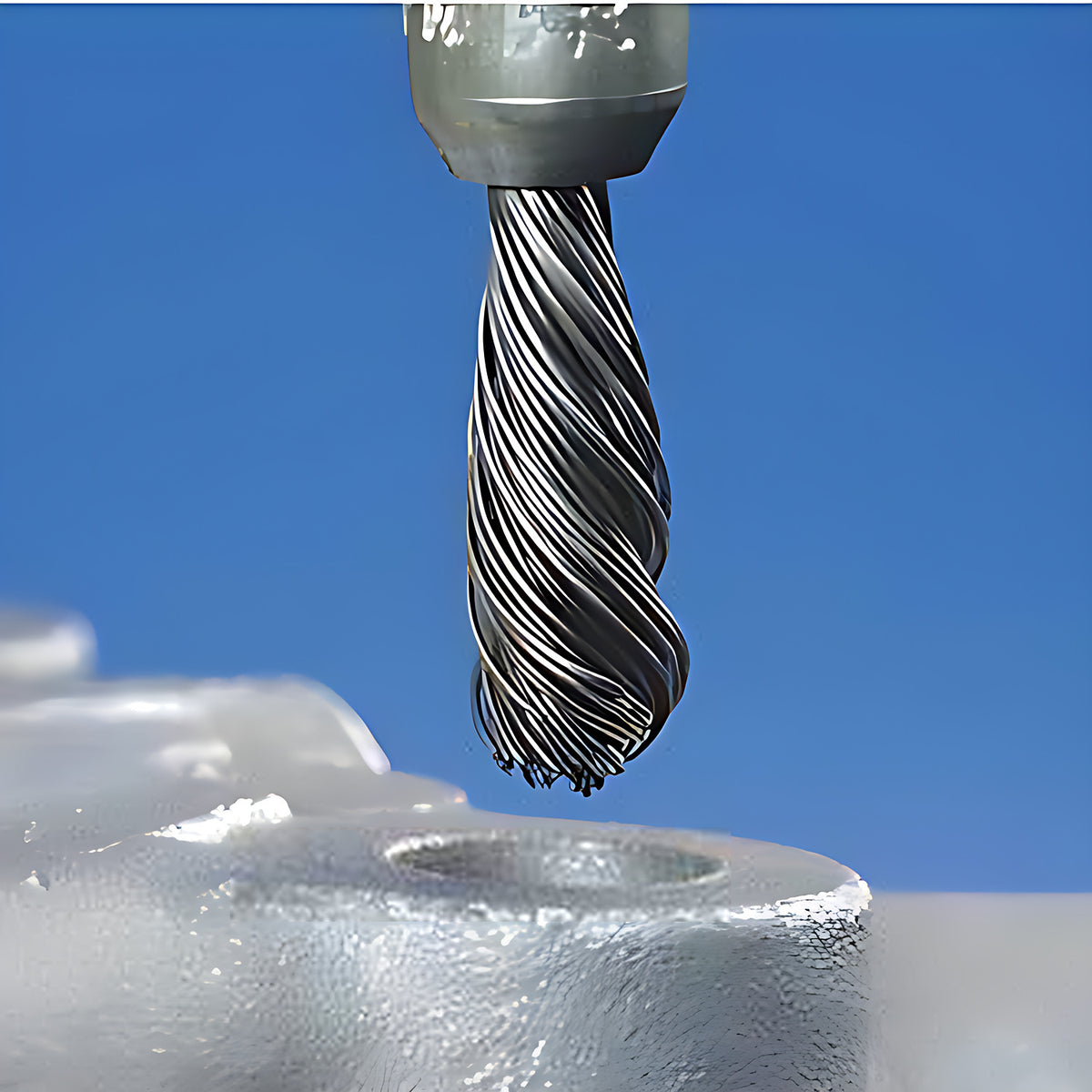 Pferd PBGS stainless single-twist pencil brush in use, close view of the twisted wire tip above a drilled hole in a casting