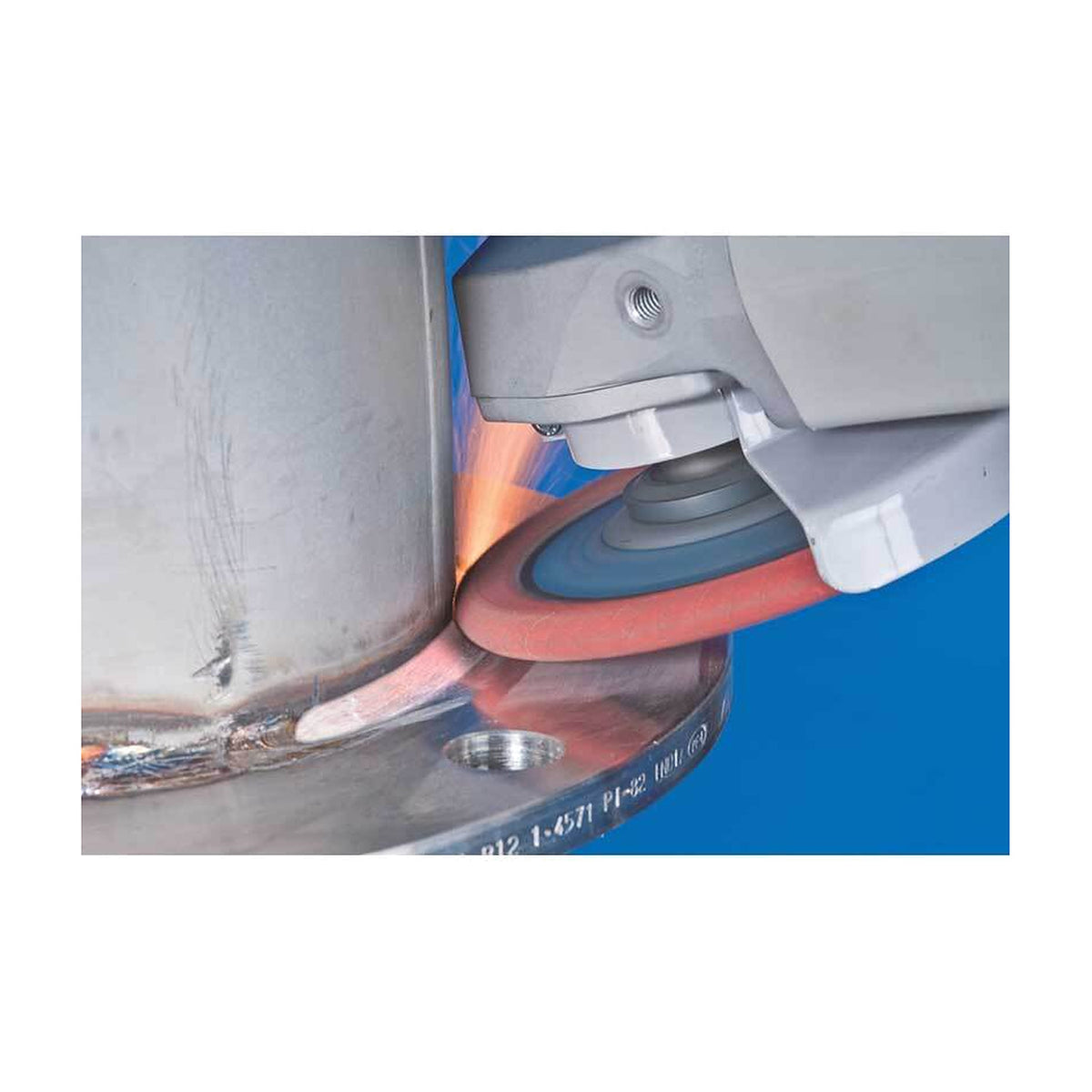 Pferd POLIFAN Curve Flap Disc CO SGP CURVE STEELOX, angle grinder with a flap disc blending a weld on a large steel flange, orange glow at the contact point, blue background