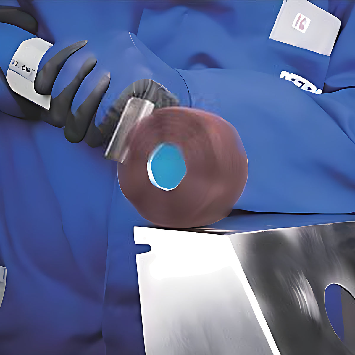 Pferd POLINOX PNG Threaded Grinding Wheel, Wavy, gloved operator holding a power tool with a pink-brown cylindrical wheel on a stainless steel part with holes, blue overalls