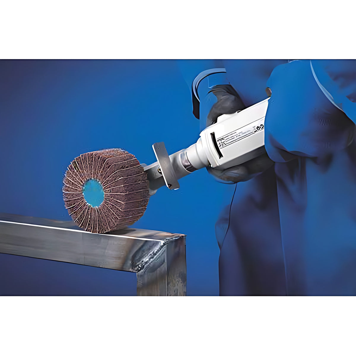 Pferd POLINOX PNZ Threaded Grinding Wheel, Radial, gloved operator holding a hand tool with a pink-brown flap wheel on a welded steel tube, blue background