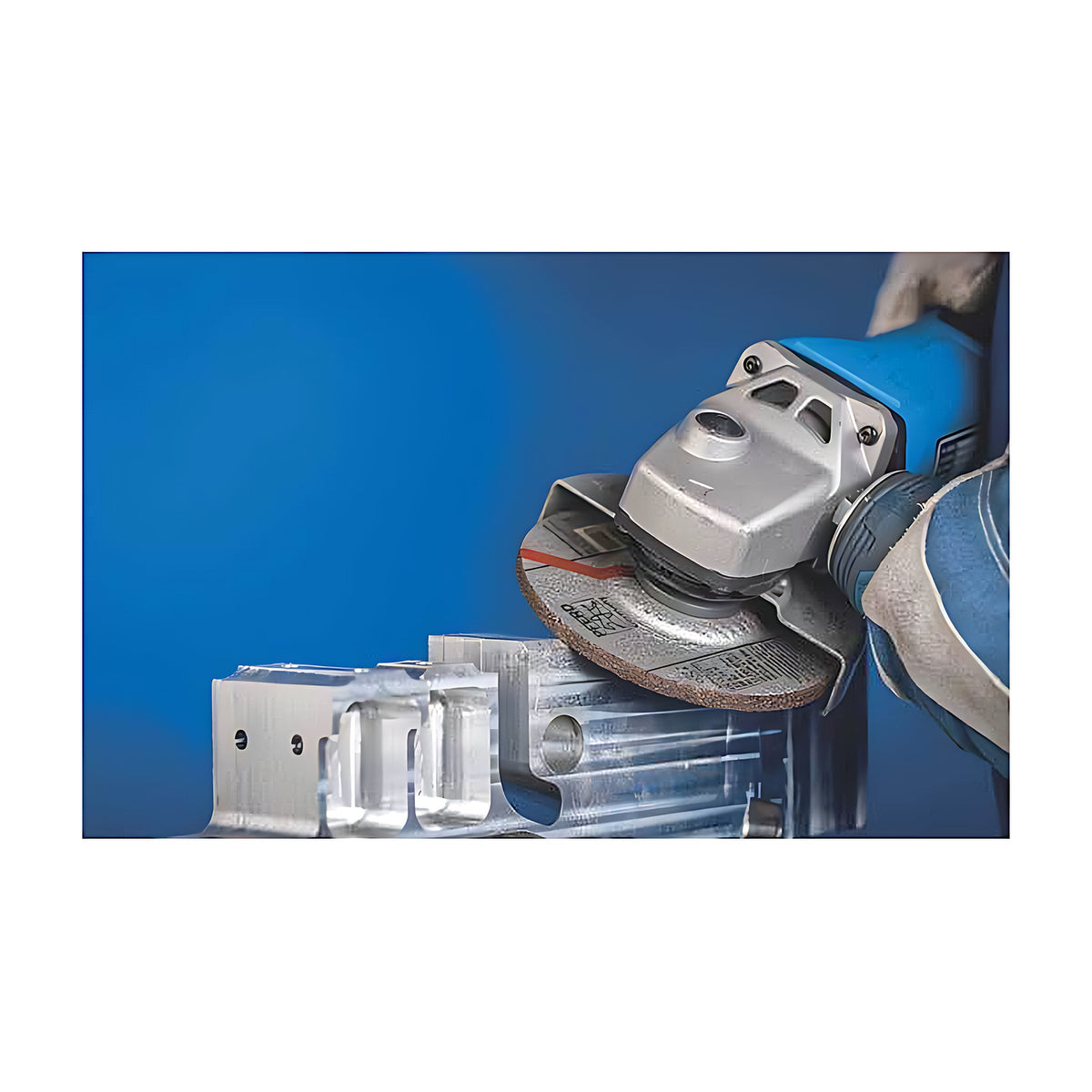 Pferd SG ALU Depressed Centre Grinding Wheel for, gloved operator using a guarded angle grinder with a wheel on a clear aluminium block, blue background